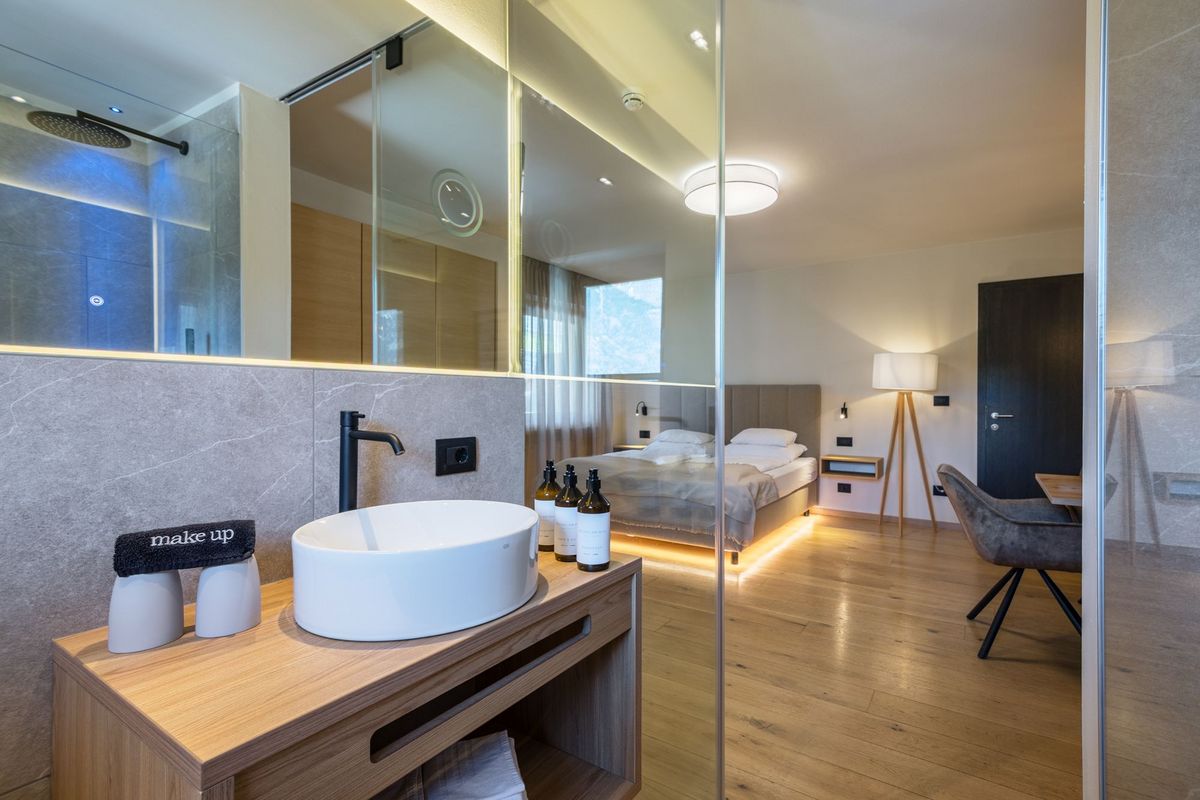 Modernes Hotelzimmer mit Waschbecken, Bett und Holzfußboden