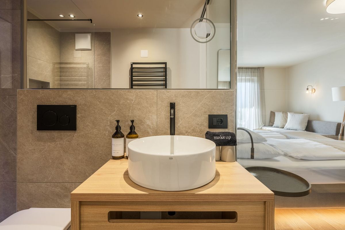 Moderner Badwaschtisch mit rundem Waschbecken und Blick ins Schlafzimmer
