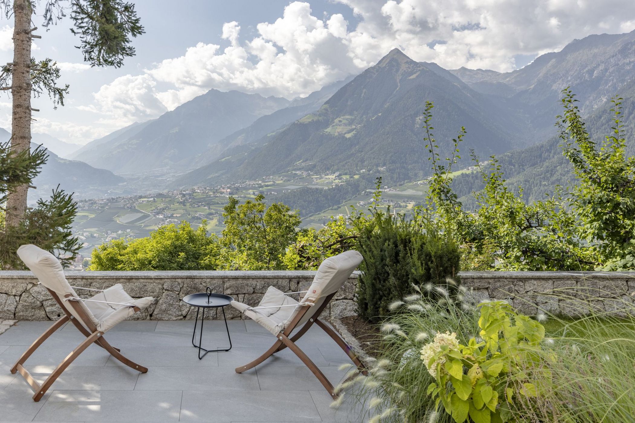 Terrazza con due sedie e tavolino con vista sulle montagne e vallata verde